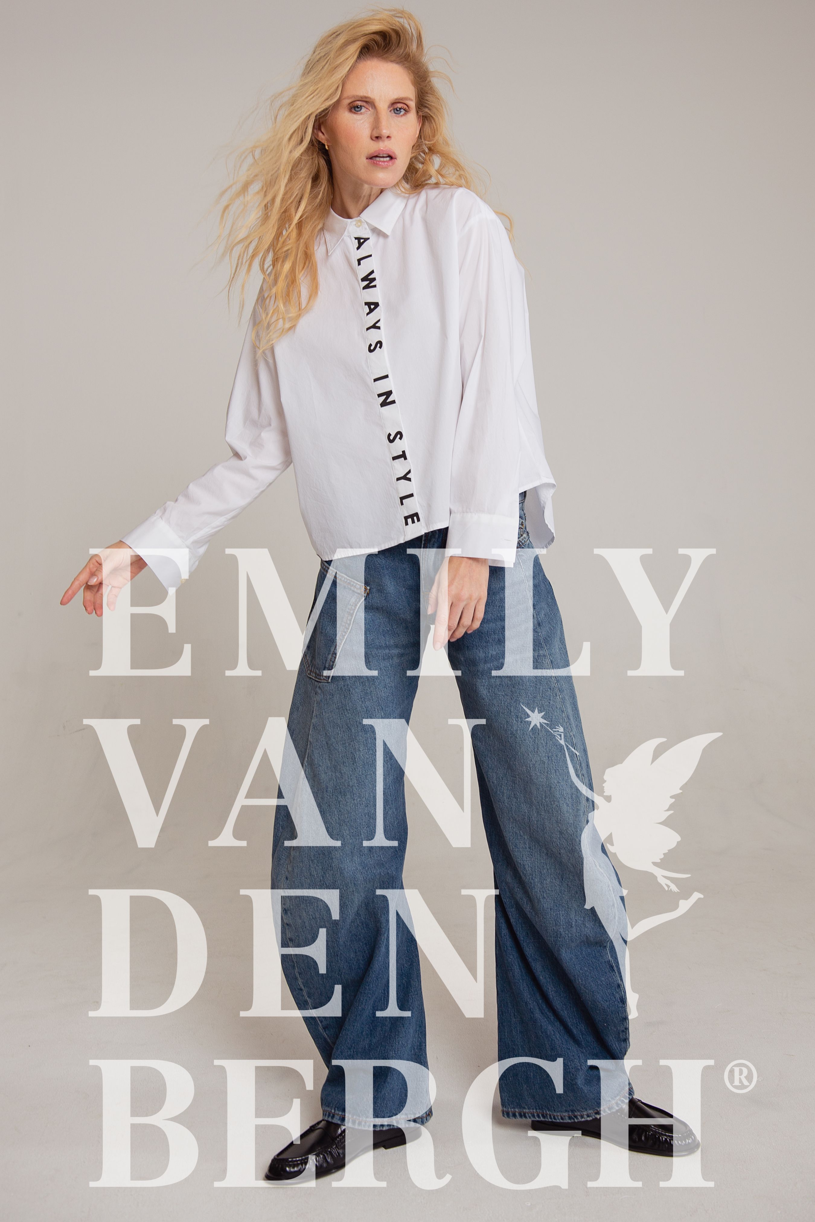 Frau trägt weißes Oversized-Hemd mit Aufdruck und weite Jeans von Emily van Den Bergh.